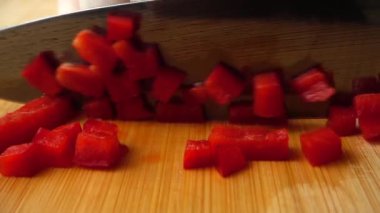Aşçı kırmızı tatlı biberi bir bıçakla keser. Yavaş çekim.