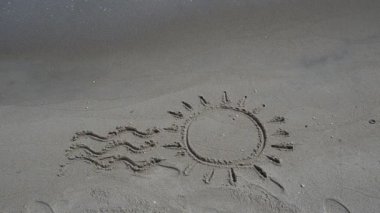 Kumsalda güneş çizimi. Kumsal ve çizim.