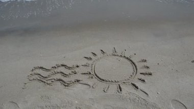 Kumsalda güneş çizimi. Kumsal ve çizim.