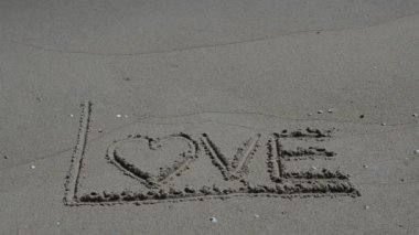 Kumsaldaki aşk işareti. Sahilde çekim yapmak..