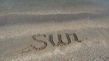 Sahildeki güneşi yazıya dök. Kuma kazınmış..