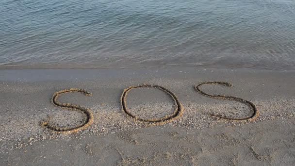 砂の上にSosの碑文 浜辺での銃撃戦 — ストック動画