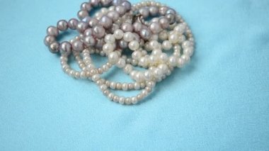 İncilerden boncuklar. Mavi ipek üzerinde çekim