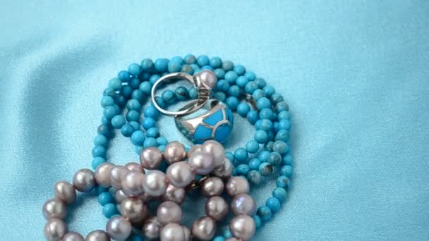 真珠のビーズ 青い絹の上で撮影 — ストック動画