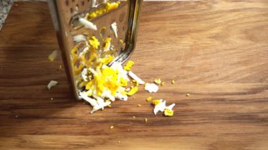 Aşçı rendeleyiciye yumurta sürer. Yavaş çekim.