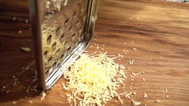 Aşçı rendeleyiciye peynir sürer. Yavaş çekim.