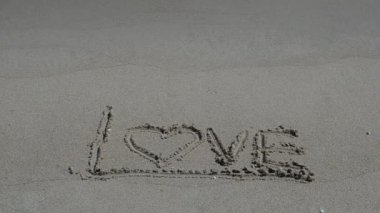 Kumsaldaki aşk işareti. Sahilde çekim yapmak..