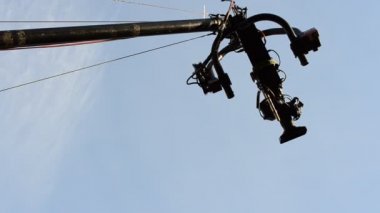 Kamera faaliyet halinde; mavi gökyüzü arka plan olarak. Vinçteki kamera.