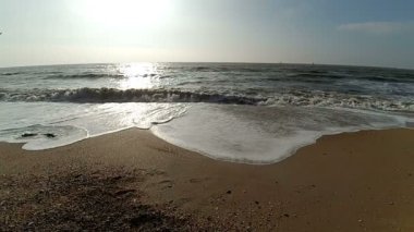 Gün batımındaki güzel deniz. Ağır çekim. Güneş, gökyüzü ve dalgalar.