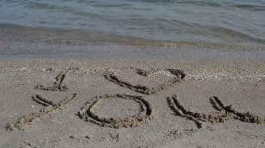 Plajdaki yazıt. Sahilde çekim yapmak. Sahilde çekim yapmak..