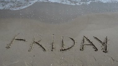 Cuma günü yumuşak dalgalı kumsalda yazıtlar. Sahilde çekim yapmak..