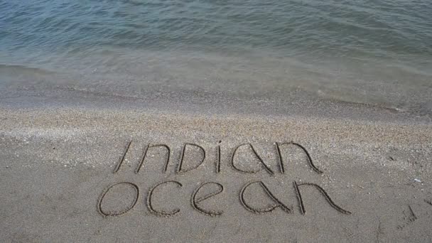 砂浜の砂の上にインド洋を記述します 浜辺での銃撃戦 — ストック動画