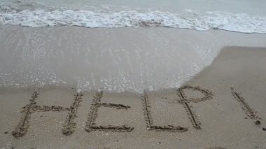 Tropikal deniz sahilinin kumsalında imza atmaya yardım et. Sahilde çekim yapmak..