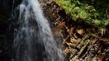 Şelale ve gökkuşağı. Ağır çekim. Dağlara düşüyor.