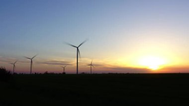 Yel değirmeni. Rüzgar çiftliği. Rüzgar türbini. Zaman atlaması çekimleri. Gün batımında çekim yapmak.