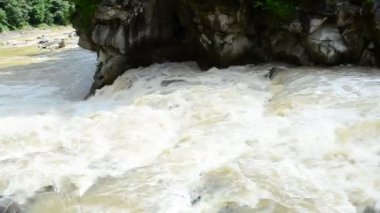 Dağ bölgesinde ateş ediliyor. Şelale ve dağ nehri