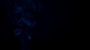 Siyah arka planda sigara içmek. Yavaş çekim.