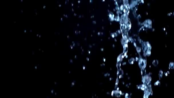 Eau sur fond noir. Mouvement lent .