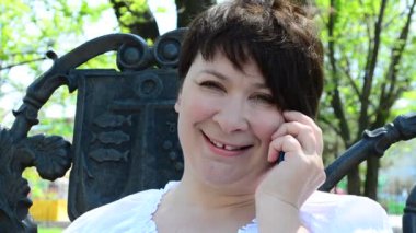 Parktaki kız, telefonla konuşuyor. Park bankında.