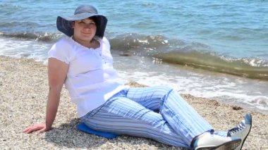 Plajdaki şapkalı kız. Kumsal ve deniz