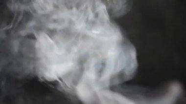 Gri duman. Siyah arkaplanda sigara iç