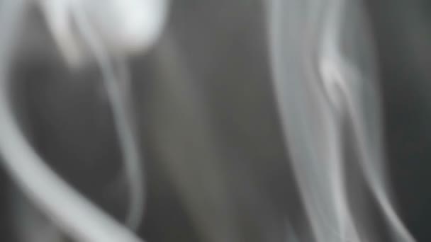 Au ralenti. La fumée du feu. Bouffées sur fond noir 