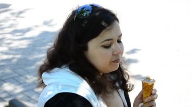 Kız dondurma yiyor. Güzel kız dondurmayı eline aldı.