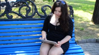 Kız tabletle çalışıyor. Kızın kucağındaki tablet.