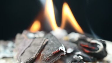 Ağır çekim. Yavaşça yanan kumaş. Ağır çekim. Siyah arkaplanda yanan kumaş
