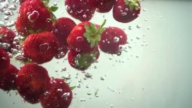 Suya düşen çilek. Yavaş çekim.