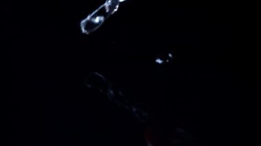 Siyah arka planda suya düşen kiraz domatesleri. Yavaş çekim.