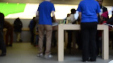 Danışmanlar, bulanık. New York, ABD. New York 'un 5. caddesindeki Apple mağazasında bilinmeyen insanlar var.