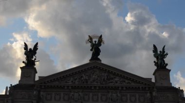 Bulutlara karşı tiyatro. Lviv, Ukrayna. Opera ve bale dünyasının en iyi tiyatrosu. Merkezi heykel Zafer, sol heykel Müzik, sağ figür Komedi ve Drama.