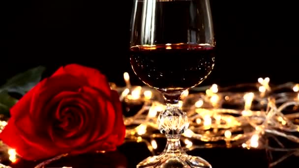 Ποτήρια Κρασιού Και Τριαντάφυλλο Στο Φόντο Των Φωτεινών Γιρλάντες — Αρχείο Βίντεο