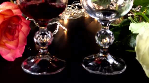 Ποτήρια Κρασιού Και Τριαντάφυλλο Στο Φόντο Των Φωτεινών Γιρλάντες — Αρχείο Βίντεο