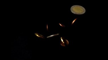 Bozuk paralar siyah arka plana düşer. Yavaş çekim.