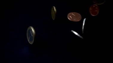 Bozuk paralar siyah arka plana düşer. Yavaş çekim.
