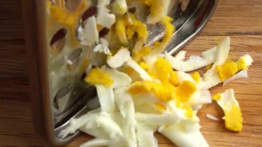 Aşçı rendeleyiciye yumurta sürer. Aşçının işi..