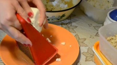 Peynir rendeliyorum. Mutfakta yemek yapıyorum..