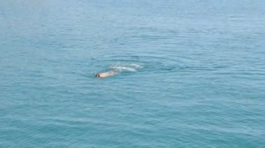 Yüzücü, deniz, yaz. Yazın uğulduyor..