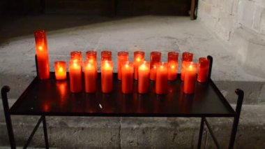 Kırmızı ve sarı saydam avizelerde kilise mumları.