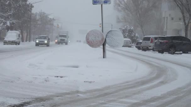 城市里的暴雪一辆汽车在白雪覆盖的路上行驶 冬季枪击案 — 图库视频影像