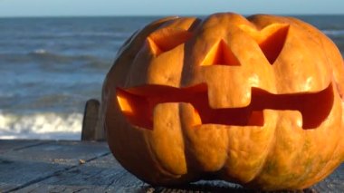 Cadılar bayramı balkabağı. Denizin arka planında çekim yapmak.