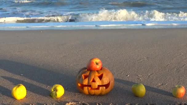 Strašidelná halloweenská dýně. Inscription Halloween na písku mořské pláže.
