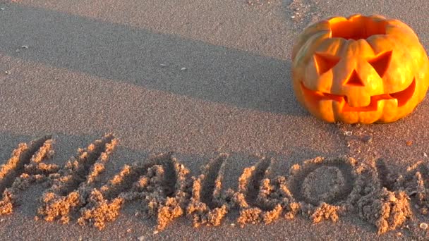 Gruseliger Halloween Kürbis Inschrift Halloween Auf Dem Sand Des Meeresstrandes — Stockvideo