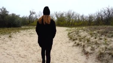 Kız bir patikaya gidiyor. Sonbaharda çekim..