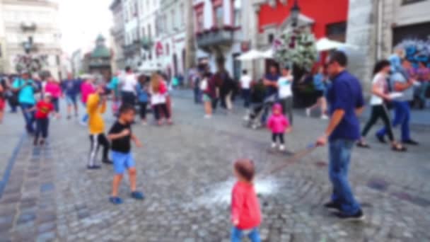 Der Mann Unterhält Kinder Auf Dem Stadtplatz Mit Seifenblasen Unscharf — Stockvideo