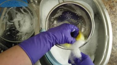 Bir kadın bulaşık yıkıyor bir su deresinin altında.