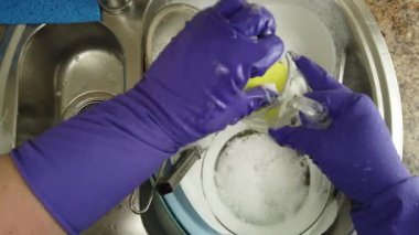 Bir kadın bulaşık yıkıyor bir su deresinin altında.