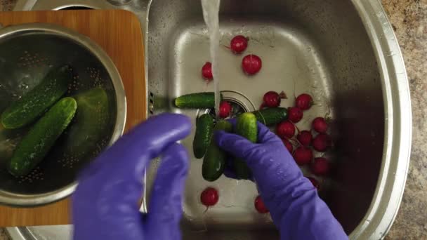 一个女人在水柱下洗黄瓜和萝卜 — 图库视频影像